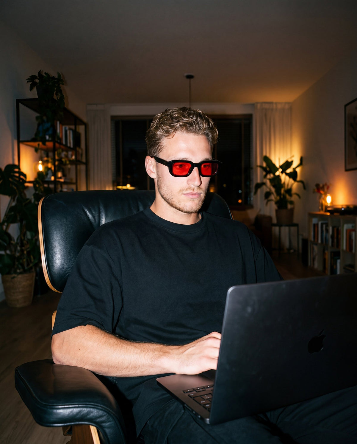 Kille jobbar vidare på laptopen med röda glasögon på